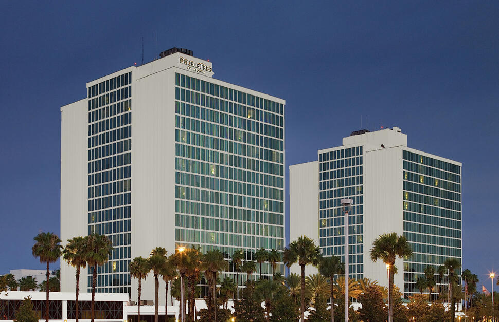hotel building, hotel exterior, nighttime, palm trees