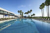 Swimming pool, sunloungers, palm trees, hotel gardens