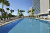 Swimming pool, sunloungers, palm trees, hotel gardens, hotel building
