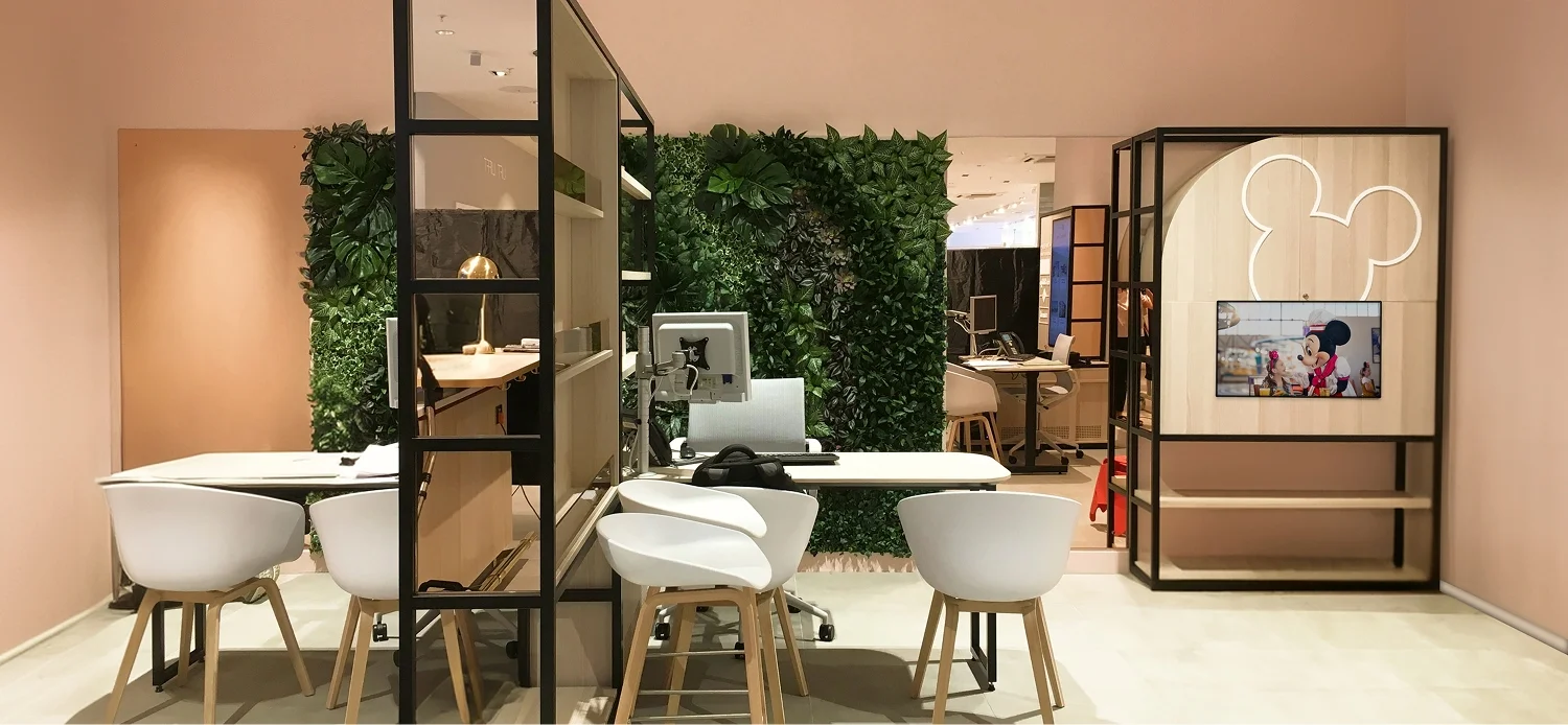 Virgin Holidays Swansea Next consultation area with desk seating green walls and a Mickey-shaped illuminated display