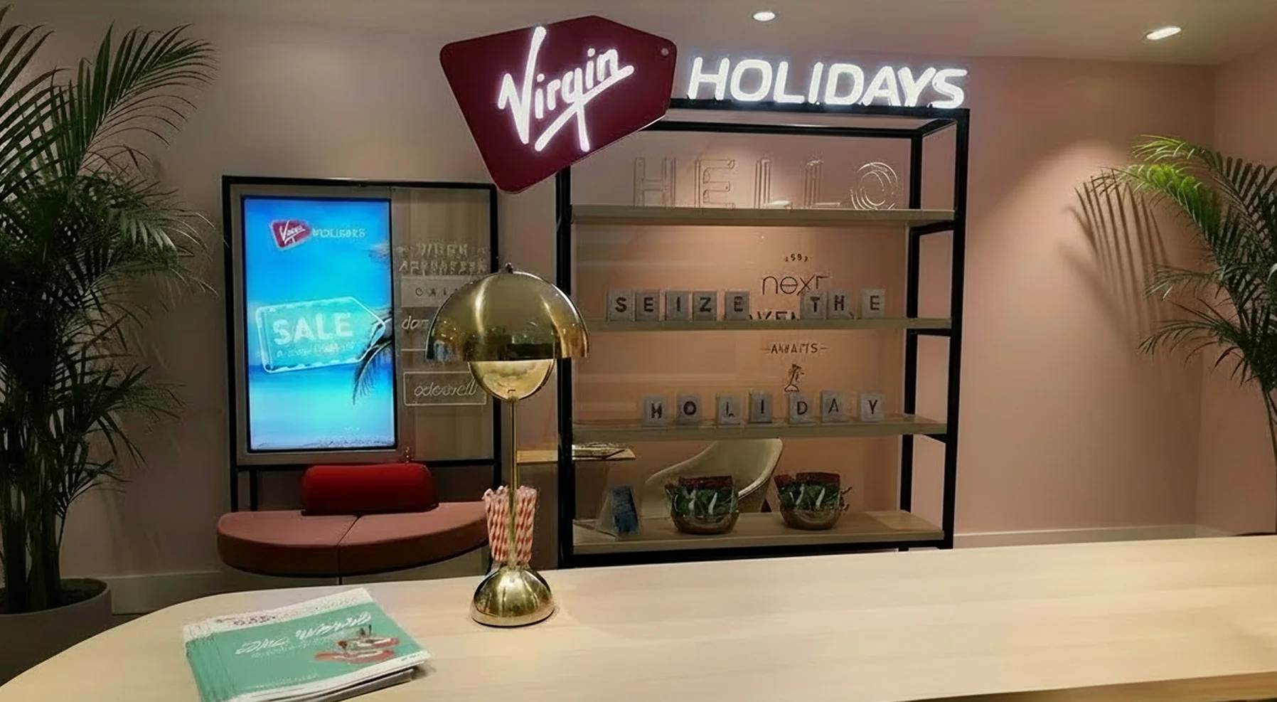 Virgin Holidays Basildon Next store with an illuminated logo display shelving a digital sale screen and lounge seating